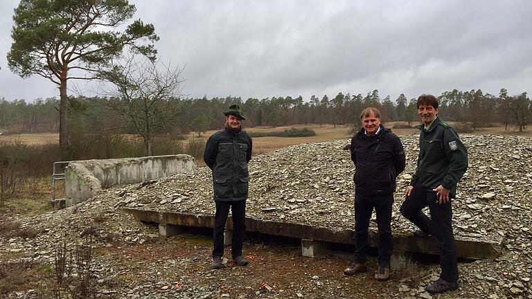 Ein alter Bunker wurde zum Fledermaushotel umfunktioniert: Werner Wahmhoff (Mitte) von der Deutschen Bundesstiftung Umwelt sowie Christian Stoewer (links) und Frank Haßlinger vom Bundesforstbetrieb Reußenberg stehen vor den Einflugschneisen für die Mopsfledermaus auf der DBU Naturerbefläche Mellrichstadt.