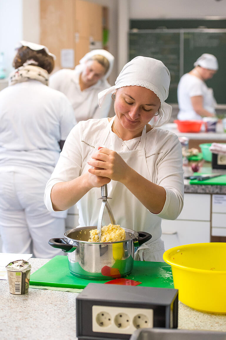 Irina Koba kümmert sich um die vegetarische Variante des Weihnachtsmenüs: Hier stampft sie das Steckrüben-Sellerie-Püree.