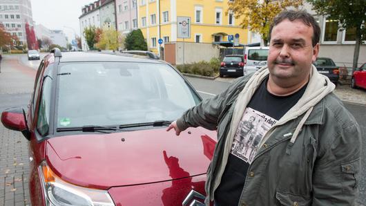 Kläger Rupert Beer zeigt am 16.10.2013 in Weiden (Bayern) auf sein Auto. Ein Liebespaar war Ende 2012 in die Garage des Tubabläsers der vom Franken-Fasching bekannten «Altneihauser Feierwehrkapell&apos;n» eingedrungen und hatte sich dort auf der Motorhaube seines Autos vergnügt und beschädigte das Fahrzeug. Beer fordert in einem Zivilverfahren von dem Pärchen 3700 Euro Schadenersatz.