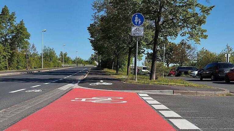 Der Bordstein ist abgesenkt und Schilder sowie Symbole zeigen, dass der Gehweg auch mit Fahrrädern befahren werden darf. Der Bordstein ist abgesenkt und Schilder sowie Symbole zeigen, dass der Gehweg auch mit Fahrrädern befahren werden darf.