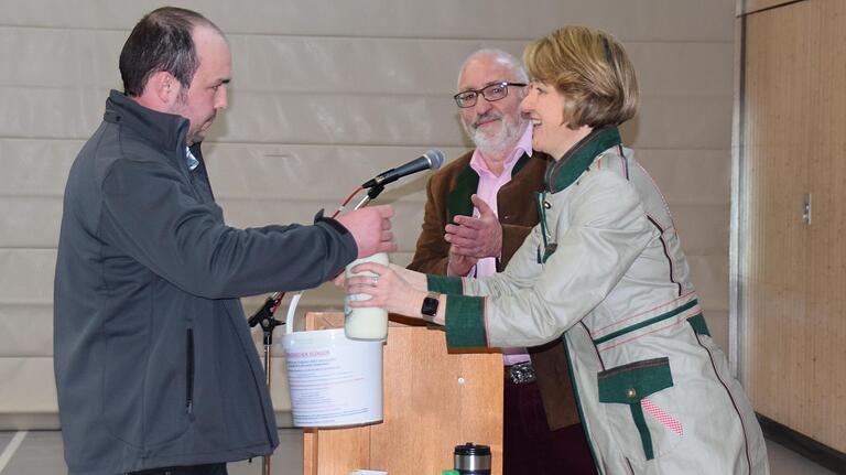 Als flüssigen Denkanstoß übergab Bio-Landwirt Florian Schuler (links) an Bundestagsabgeordnete Anja Weisgerber einen Liter Milch und drei Liter Gülle, die eine Kuh verursacht, bis sie einen Liter Milch produziert. Beobachter dabei war Otto Kremling (Mitte), stellvertretender Bezirksvorsitzender AG Ernährung, Landwirtschaft und Forsten der CSU.