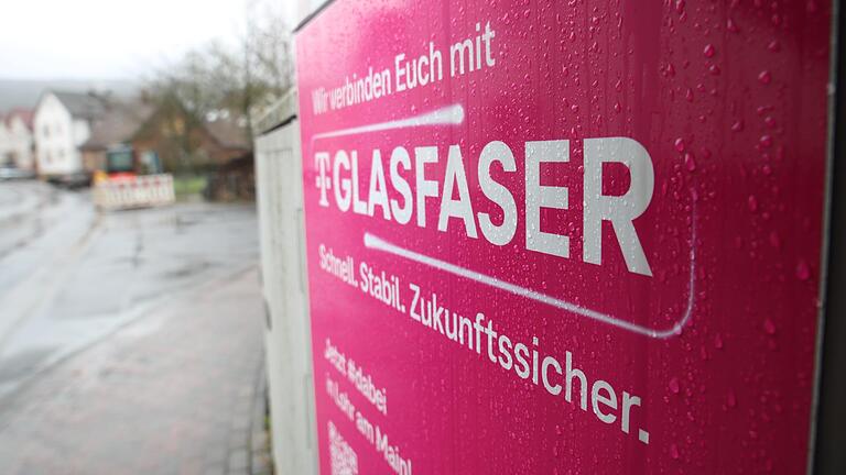 Der Glasfaserausbau durch die Telekom in Lohr ist nach der Winterpause wieder angelaufen. Im Bild ein Verteilerkasten in Wombach mitsamt Werbeplakat der Telekom, im Hintergrund eine Glasfaserbaustelle. Der Glasfaserausbau durch die Telekom in Lohr ist nach der Winterpause wieder angelaufen. Im Bild ein Verteilerkasten in Wombach mitsamt Werbeplakat der Telekom, im Hintergrund eine Glasfaserbaustelle.