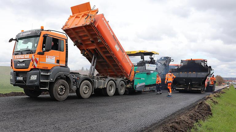 Logistik ist alles auf einer Baustelle wie dieser. Ein Kipplaster bringt vom Mischwerk Nachschub an frischem Asphalt.