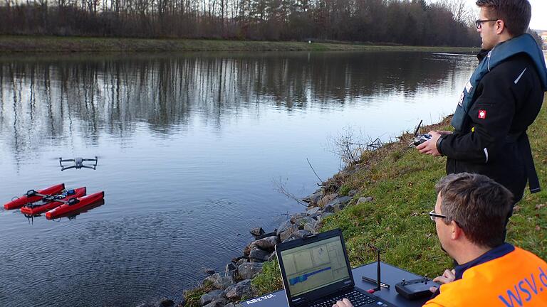 Teamarbeit: Jörg Schackel (links) bringt die Drohne in Position und verfolgt die Messdaten auf seinem Laptop. Alexander Baumgartl bewegt das Messboot auf dem Main nach Anweisung des Hydrologen