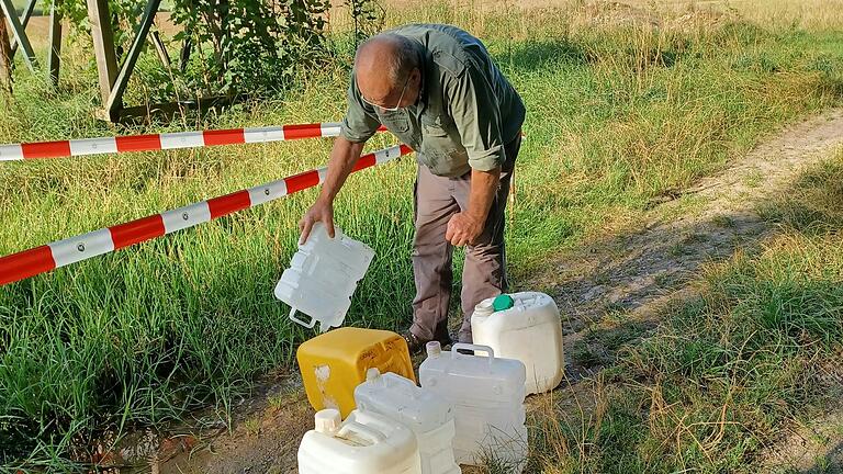 Mit Wasserkanistern haben Mitglieder des Ortsvereins des Nabu in Großrinderfeld, hier Hubert Schulsche, dafür gesorgt, dass ein Teich nicht austrocknete und so Teichmolche gerettet werden konnten.