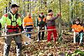 Mit Schwung bringt Jürgen Pöhlmann die 3,65 Meter lange Gertstange in Position. Raimund Träger und Reinhard Wolf beobachten ihn dabei. Rechtler-Vorsitzender Thomas Wintzheimer markiert die Grenze zweier Lauben mit roter Farbe, Hieronymus Konrad schlägt einen Grenzstickel in den Waldboden.