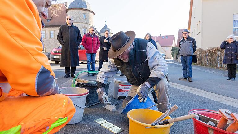 Unterstützt von Bauhofmitarbeiter Klaus Gransitzki brachte Gunter Demnig drei Stolpersteine vor dem Haus in der Kirchgasse in den Straßenbelag ein, das einst von der jüdischen Familie Baumann bewohnt war.