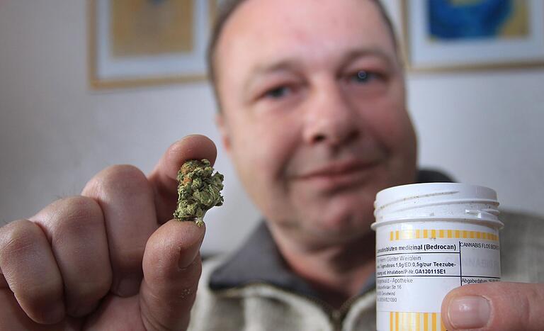 Günter Weiglein mit einer getrockneten Cannabisblüte und der dazu gehörigen Medizindose. Er bekommt Cannabis nach einem Motorradunfall zur Schmerztherapie. Günter Weiglein mit einer getrockneten Cannabisblüte und der dazu gehörigen Medizindose. Er bekommt Cannabis nach einem Motorradunfall zur Schmerztherapie.