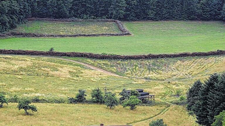 Wallanlage: Mehrere Kilometer durchziehen Totholzwälle (Benjeshecken) die Deutelbacher Landschaft. Dieter Dauth hat damit etwa ein Drittel der Gemarkung eingefasst. Das verstoße unter anderem gegen den nach der Verfassung zu gewährenden freien Zugang zur Natur, urteilten Würzburger Richter 2010. Dagegen hat Dauth Berufung eingelegt.