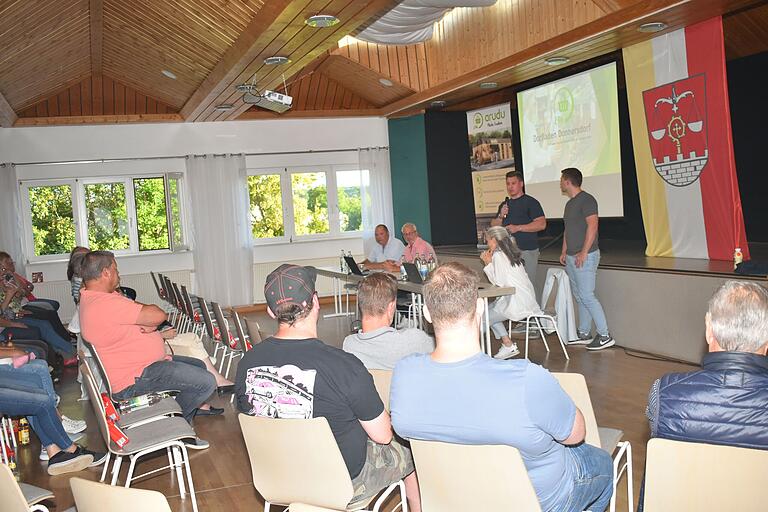 Das Bild zeigt Pascal Timmel (mit Mikrofon) bei der Präsentation des geplanten Ladens.