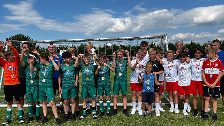 Siegermannschaft JSG Külsheim (links im grünen Trikot) mit ihrem Trainer, rechts der Zweitplatzierte SGM Krautheim, in den blauen T-Shirts die beiden Jugendleiter vom FCH David Münkel und Tim Ballweg, die den Pokal und die Siegermedaillen überreichten.