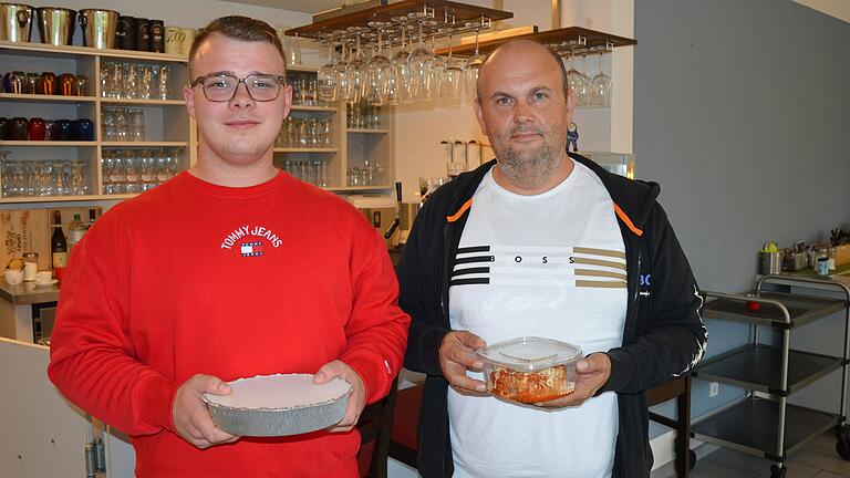 Ismet und Vejsil Celic, Inhaber des Hole 19 in Kitzingen, zeigen zwei Schalen mit übrig gebliebenen Mittagsgerichten, die sie über die App Too Good To Go zu einem Drittel des eigentlichen Verkaufspreises verkaufen. Ismet und Vejsil Celic, Inhaber des Hole 19 in Kitzingen, zeigen zwei Schalen mit übrig gebliebenen Mittagsgerichten, die sie über die App Too Good To Go zu einem Drittel des eigentlichen Verkaufspreises verkaufen.