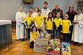 Der KoKi-Chor unter Leitung von Christel Schlensok sowie die Ministranten mit WGF-Leiter Jonas Wiesner und dem Vertreter der Lohrer Tafel, Michael Donath, hinter den gesammelten Spenden.