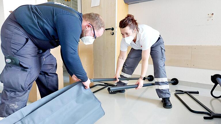 Helfer der Freiwilligen Feuerwehr Erlenbach und der Bereitschaft des Bayerischen Roten Kreuzes Karbach beim Aufbau von Feldbetten für Geflüchtete in den Patientenzimmern des ehemaligen Krankenhauses in Marktheidenfeld. Helfer der Freiwilligen Feuerwehr Erlenbach und der Bereitschaft des Bayerischen Roten Kreuzes Karbach beim Aufbau von Feldbetten für Geflüchtete in den Patientenzimmern des ehemaligen Krankenhauses in Marktheidenfeld.