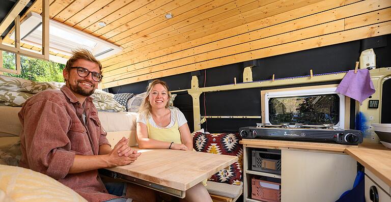 Franzi und Chris Schwietering sitzen gemeinsam am Tisch in ihrem umgebauten Bus. Franzi und Chris Schwietering sitzen gemeinsam am Tisch in ihrem umgebauten Bus.