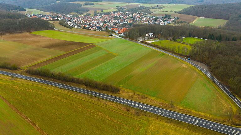 Rechts der im Vordergrund verlaufenden Staatstraße und links der Einfahrt nach Üchtelhausen ist das Gewerbegebiet 'Zeller Berg' geplant. Dagegen werden derzeit Unterschriften gesammelt, um per Bürgerentscheid diese geplante Entwicklung zu stoppen.