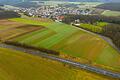 Rechts der im Vordergrund verlaufenden Staatstraße und links der Einfahrt nach Üchtelhausen ist das Gewerbegebiet 'Zeller Berg' geplant. Dagegen werden derzeit Unterschriften gesammelt, um per Bürgerentscheid diese geplante Entwicklung zu stoppen.