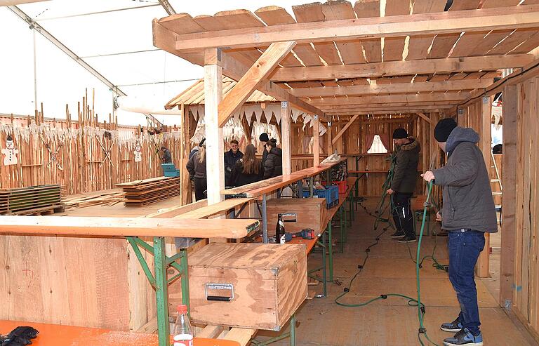 Jede Menge Holz wird für den Aufbau der Ski-Hütte im Zelt der Eisbär-Party verbaut.