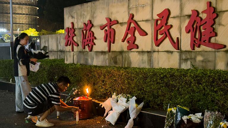 Autofahrer tötet mehrere Menschen in China       -  Menschen legen Blumen vor einem Sportzentrum nieder, wo ein Mann mit seinem Auto 35 Menschen tötete.