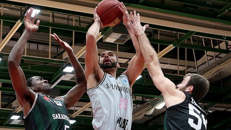 Basketball - FIBA Europe Cup - s.Oliver Wuerzburg - Sakarya BSB       -  Schwerer Stand: Würzburgs Perry Ellis (Mitte) beim Wurfversuch gegen Sakaryas Alan Herndon (links) und Kerem Özkan.