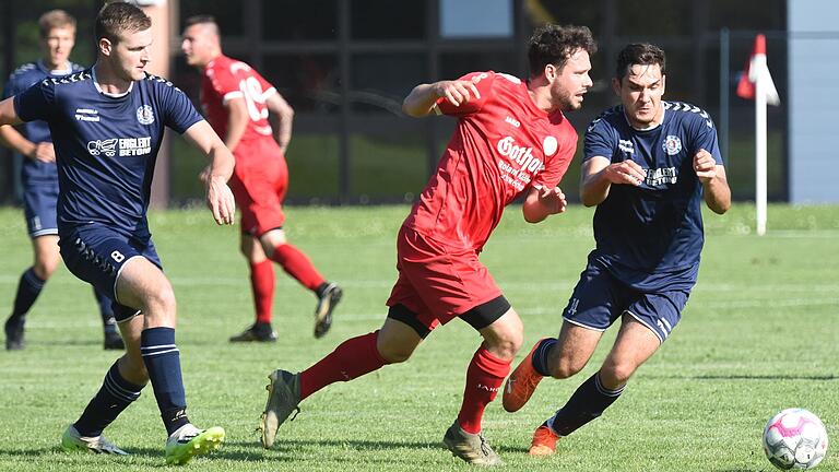 Der TSV-DJK Wülfershausen (links Marcel Fischer, Schütze des 2:0; rechts Benedikt Stuhl) brach nach sechs Niederlagen den Bann und gewann beim FV Rannungen/Pfändhausen/Holzhausen&nbsp; (Mitte Spielertrainer Benjamin Kaufmann) unerwartet deutlich mit 3:0.