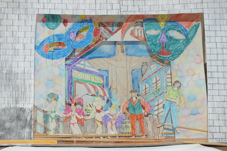 Blick in ein farbenfrohes Papiertheater. Die Schüler haben Rio de Janeiro als Thema gewählt mit Sambatänzerinnen und Carnevalsmasken vor der monumentalen Christusstatue. Blick in ein farbenfrohes Papiertheater. Die Schüler haben Rio de Janeiro als Thema gewählt mit Sambatänzerinnen und Carnevalsmasken vor der monumentalen Christusstatue.