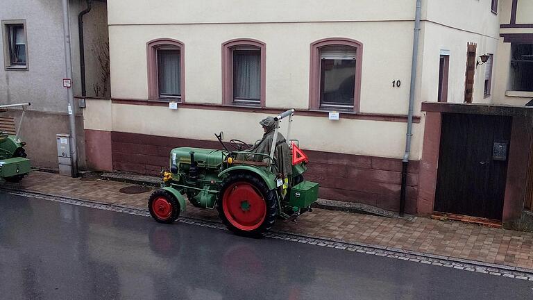Im Regencape harrt dieser Fahrer auf seinem Traktor aus. - Im Regencape harrt dieser Fahrer auf seinem Traktor aus. Im Regencape harrt dieser Fahrer auf seinem Traktor aus. - Im Regencape harrt dieser Fahrer auf seinem Traktor aus.