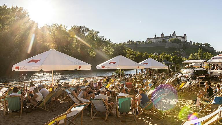 An warmen Tagen besuchen viele Menschen gerne den Stadtstrand am Main in Würzburg.