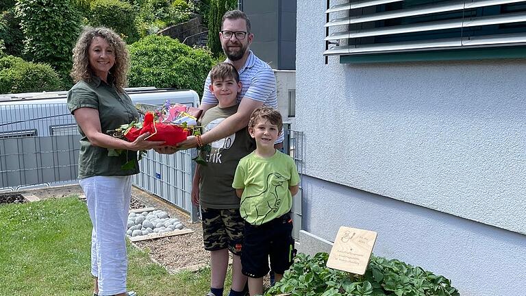 Mit einer Auflaufform, die sich bestens für die Zubereitung von Kartoffelgratin eignet, bedankte sich Eva-Maria Stühler bei Matthias Gräf (im Bild mit seinen Kindern) für den Bau der „Kartoffelpyramide“.