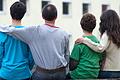 Eine syrische Familie sitzt vor einem Asylwohnheim.