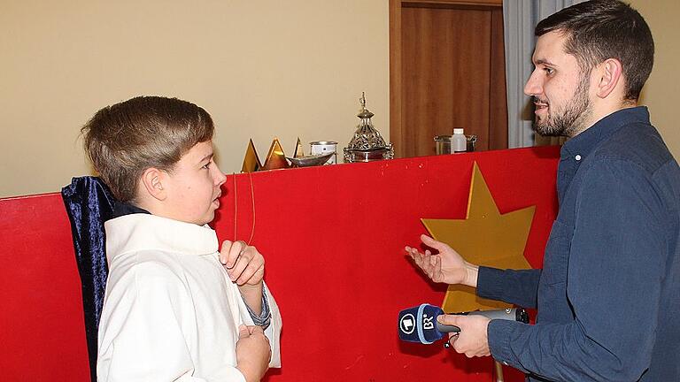 Der Radiosender Bayern 1 bat die Kirchschönbacher Sternsinger, hier Christoph Dusel, bei der Anprobe der Kleider, zum Interview. Vier Ministranten aus der Gemeinde vertreten das Bistum Würzburg beim Empfang bei Kanzlerin Angela Merkel in Berlin.