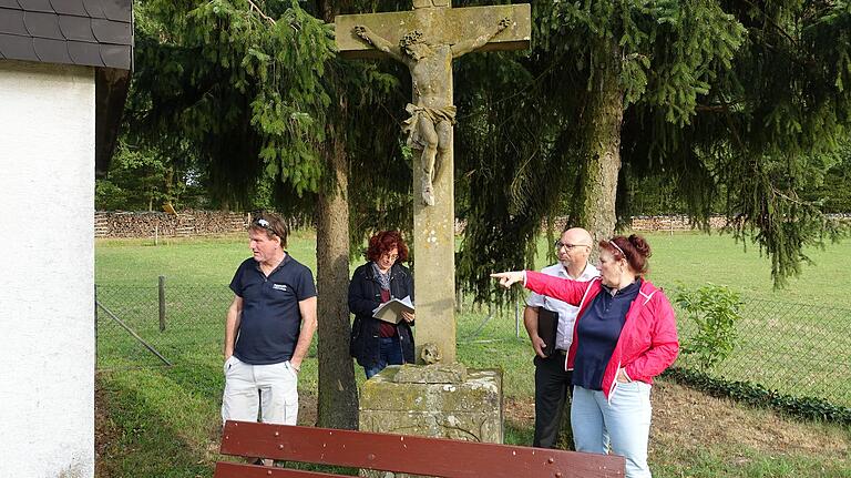 Das Kreuz im Friedhof Neutzenbrunn will der Obst- und Gartenbauverein renovieren lassen. Im Bild (von links) Stadtrat Klaus-Dieter Schubert, OGV-Vorsitzende Beate Köhler, Bürgermeister Jürgen Lippert und Ingrid Meier aus Neutzenbrunn.