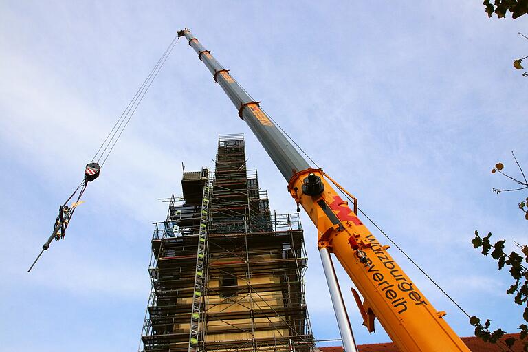 Eine kleine Last für den Autokran, eine große Freude für Stadelschwarzach: Das neue Turmkreuz kommt auf die Kirchturmspitze. Eine kleine Last für den Autokran, eine große Freude für Stadelschwarzach: Das neue Turmkreuz kommt auf die Kirchturmspitze.