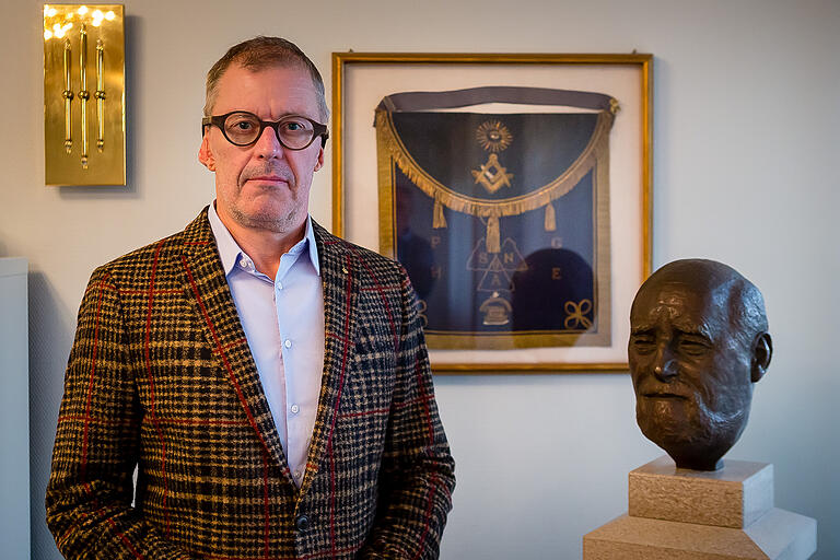 Stefan Muffert, Meister vom Stuhl der Schweinfurter Freimaurerloge 'Brudertreue am Main'. Die Büste zeigt Theodor Vogel, der als der Einiger der deutschen Freimaurer nach der Verbotszeit während des Nationalsozialismus gilt. Im Rahmen an der Wand ein historischer Schurz, wie ihn die Freimaurer während ihrer Tempelarbeit tragen.