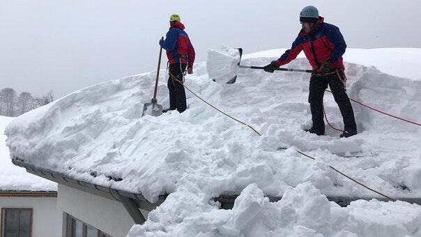 Gesichert wie bei einer Bergtour: Mitarbeiter der Bergwacht Oberbach helfen seit Sonntag in Pieding im Landkreis Traunstein. Auch eine Reha-Klinik wurde dabei von den Schneemassen befreit. Zum sechsköpfigen Team gehören auch zwei Waldberger.