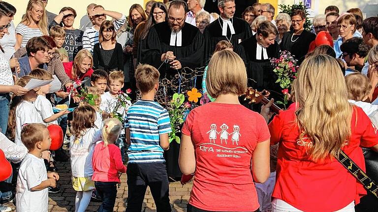 Die Kinder der Kindertagesstätte begrüßten das neue Pfarrerehepaar Mertten vor der Pfarrkirche im Beisein von Dekan Dr. Matthias Büttner, Pfarrerin Hofmann-Landgraf, dem katholischen Amtsbruder Florian Lehnert und Bürgermeisterin Angelika Götz herzlich und überreichten symbolische Geschenke.