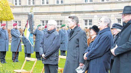 Volkstrauertag: Friede ist mehr als ein Schweigen der Waffen       -  (fan)   &bdquo;Friede ist mehr als ein Schweigen der Waffen&ldquo;, sagte Oliver Bruckmann am Sonntagmorgen bei der Gedenkfeier zum Volkstrauertag, &bdquo;Shalom, Friede, kann nur mit Freiheit und Gerechtigkeit zusammen genannt werden.&ldquo; Der evangelische Dekan sprach die Worte zur geistlichen Besinnung anlässlich der Feierstunde am Ehren- und Mahnmal der Opfer der Kriege im Alten Friedhof. &bdquo;Und deshalb dürfen wir nicht aufhören, in der Welt und mit der Welt um den Frieden zu ringen&ldquo;, so Bruckmann. Dafür betete er zusammen mit seinem katholischen Dekanskollegen Pfarrer Reiner Fries. OB Sebastian Remelé hatte die Gäste zur Gedenkfeier begrüßt &ndash; meist Ältere und Lokalpolitiker. Remelé erinnerte an die Opfer der Völkerschlacht bei Leipzig vor genau 200 Jahren ebenso wie an die Verbrechen der Nazis im Zweiten Weltkrieg &ndash; von der Judenverfolgung bis zum Bombenkrieg in Schweinfurt als Folge der Menschen und Völker verachtenden Politik. &bdquo;Deutsche waren Täter und Opfer&ldquo;, sagte der Oberbürgermeister, &bdquo;weder auf die eine, noch auf die andere Rolle haben wir ein Monopol.&ldquo; Der Volkstrauertag als Tag des Gedenkens der Kriegstoten dürfe sich nicht in Rückschau und Tradition ergehen, &bdquo;sondern er mahnt uns, die richtigen Schlüsse daraus zu ziehen&ldquo;, sagte Winfried Huppmann, Kreisvorsitzender des VdK Schweinfurt. So sei die europäische Einigung dem festen Willen entsprungen, dauerhaft den Frieden zu sichern. Zum Lied vom guten Kameraden salutierte die zehnköpfige Ehrenformation der Bundeswehr. Der evangelische Posaunenchor begleitete die Feier musikalisch. Vorne (von links) Huppmann, Remelé, Fries und Bruckmann.