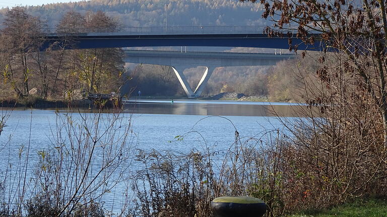 Als schmales blaues Band überspannt die neue Gemündener Mainbrücke den Fluss, vor der wuchtigen Betonkonstruktion der ICE-Linie Würzburg–Hannover im Hintergrund.