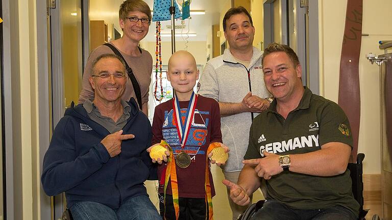 Paralympics-Größen sorgten bei ihrem Besuch in der Station Regenbogen der Würzburger Uniklinik für sportliche Stimmung. Im Bild: (von links) Errol Marklein, Franziska Liebhardt, der zehnjährige Patient Luis, Christian Zeilermeier und Daniel Scheil.FOTO: Patty Varasano