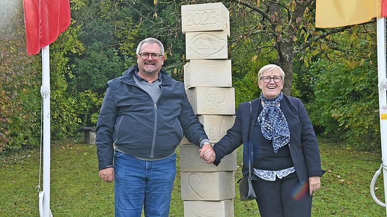 Hand in Hand stehen Kleinrinderfelds Bürgermeister Harald Engbrecht und die Partnerschaftsbeauftragte der Gemeinde Colleville Montgomery, Odile Hardy, vor der frisch enthüllten Stele, die einen weiteren Meilenstein der Städtepartnerschaft zwischen Kleinrinderfeld und Colleville Montgomery kennzeichnet.