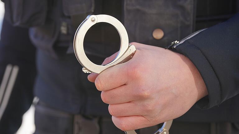 Polizei Handschellen - Symbolbild       -  SEK-Beamte nehmen einen Mann fest, der mit einem Gewehr gedroht haben soll. (Illustration)