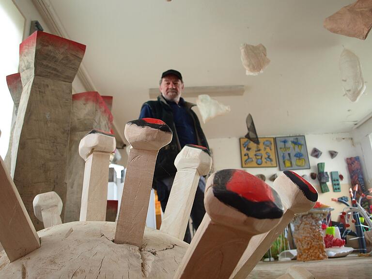 Jan Polacek und eines seiner Holzobjekte.