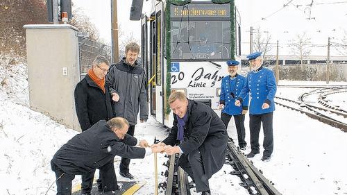 Handwerklicher Einsatz zum 20-jährigen Bestehen der Straba-Linie 5: An der goldenen Schraube drehen Paul Lehmann (links) und WVV-Geschäftsführer Norbert Menke. Über die positive Entwicklung der Straßenbahn in Würzburg freuen sich auch Geschäftsführer-Kollege Thomas Schäfer (hinten links) und Aufsichtsratsvorsitzender Matthias Pilz.