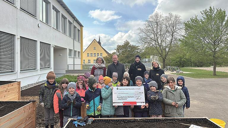 Freuen sich über die Hochbeete: Schülerinnen und Schüler der Grundschule Ostheim mit (von links) Schulleiterin Stephanie Urban, Wolfgang Sauer (Nachhaltigkeitsbeauftragter der Sparkasse Bad Neustadt) sowie Julian und Carina vom Verein 'Acker'.