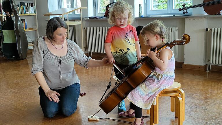 Lehrkraft für Violoncello mit interessierten Kindern.