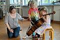 Lehrkraft für Violoncello mit interessierten Kindern.