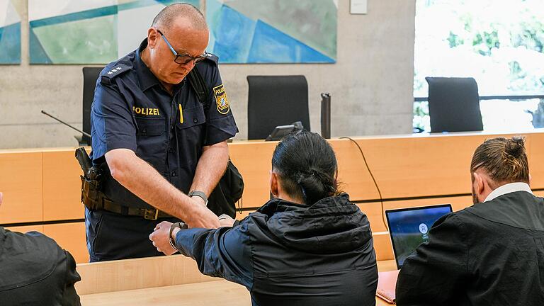 Prozess um zweifachen versuchten Mord am Landgericht Würzburg: Vor Verhandlungsbeginn nimmt ein Polizeibeamter dem 20-jährigen Hauptangeklagten die Handschellen ab.&nbsp;&nbsp;