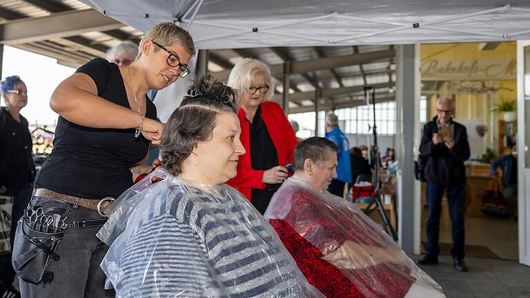 Tanja Seuffert (vorne) ist zum zweiten Mal beim Beauty Day der Bahnhofsmission dabei und lässt sich von Friseurin Carina Hirsch (links) die Haare schneiden.