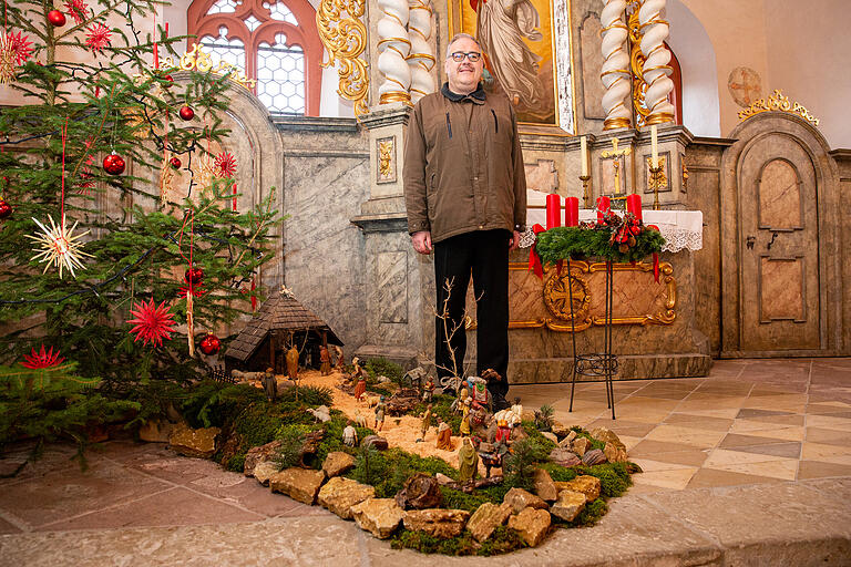 Pfarrer Gerhard Hanft in der für Weihnachten festlich geschmückten Kirche in Röttingen.