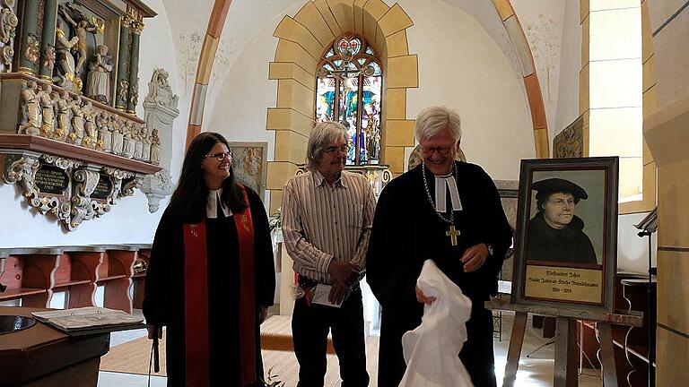 Enthüllung: Ein Lutherbildnis von Reinhold Fiederer (Mitte) wird seinen Platz an der Predigtkanzel finden.